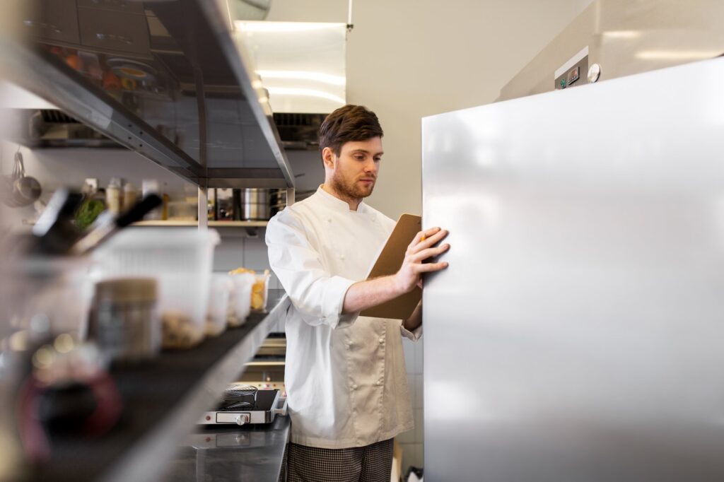 Chef reviewing commercial refrigeration equipment in a kitchen